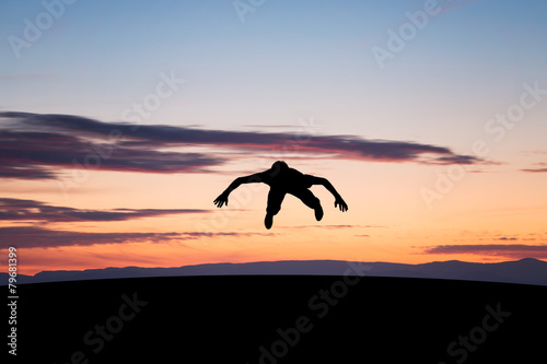 Fototapeta Naklejka Na Ścianę i Meble -  silhouetted young man jumping in sunset