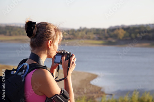 Young woman tourist with camera on nature