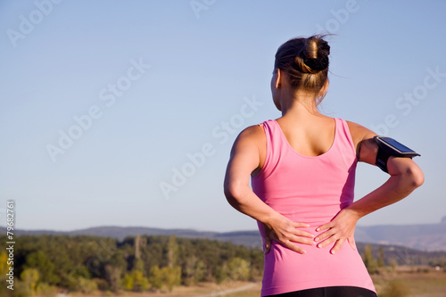 Girl after fitness feels pain in the back
