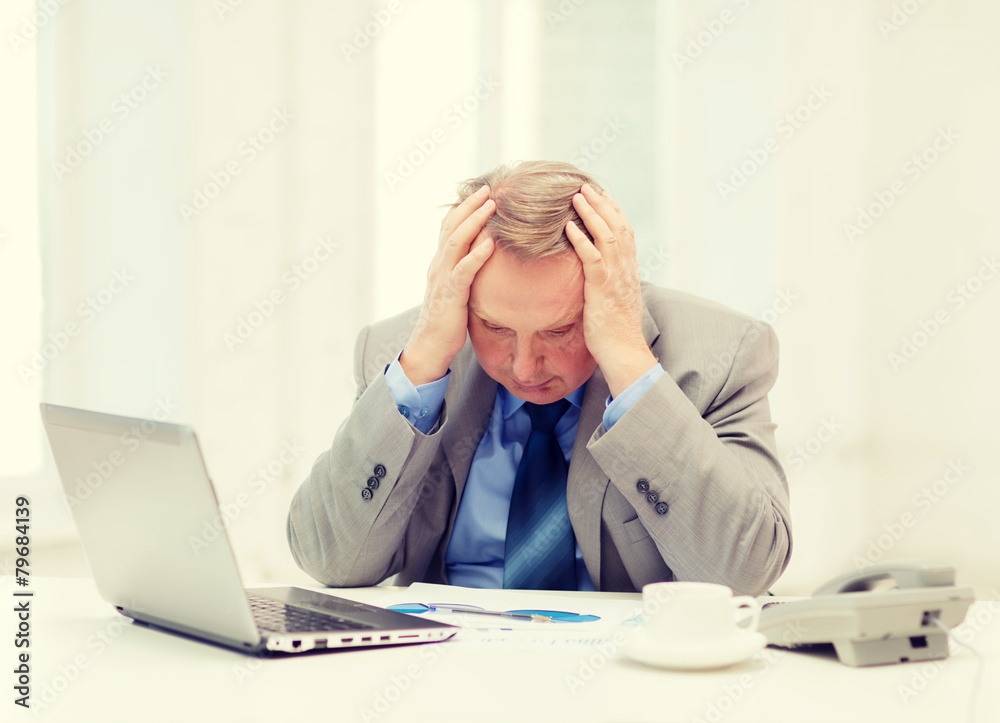 upset older businessman with laptop and telephone upset older businessman with laptop and telephone