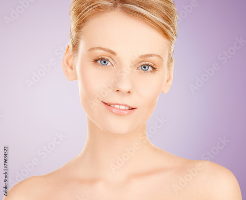beautiful young woman face over violet background