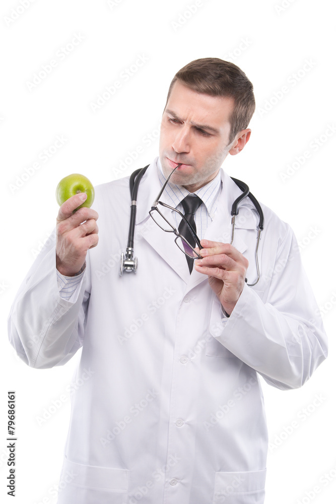 Serious male doctor looking at a green apple. Isolated Serious male doctor looking at a green apple. Isolated