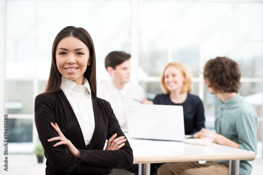 Businesswoman looking at camera with her business team on Businesswoman looking at camera with her business team on