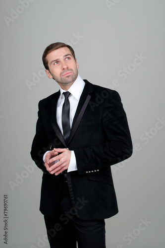 Businessman thinking and having ideas on a grey background with