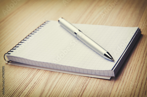 Blank notepad with pen on office wooden table