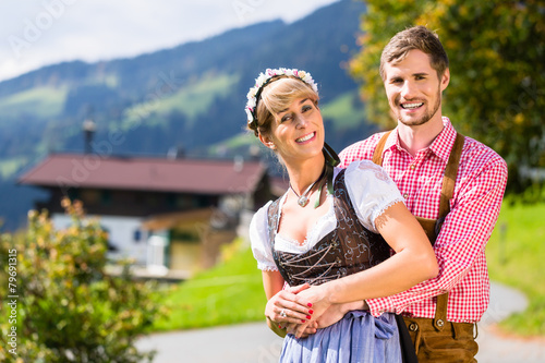 Paar in Tracht steht auf Alm in den Alpen photo