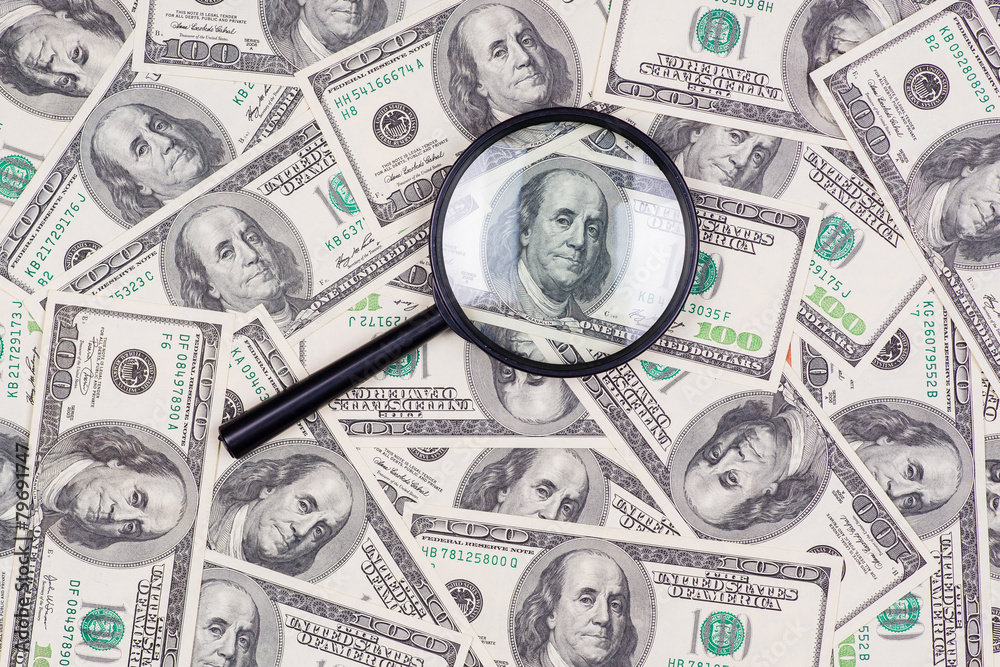 Hundred dollar banknote under magnifying glass Hundred dollar banknote under magnifying glass