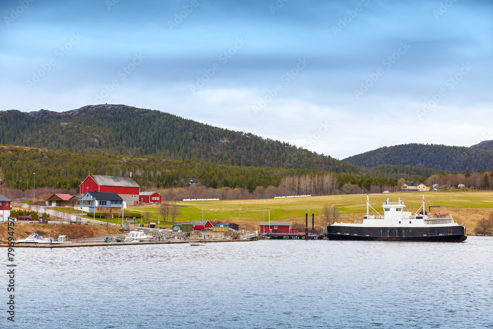 Norwegian small village with colorful wooden houses and ferry