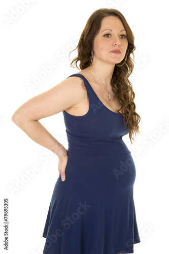 pregnant woman in blue dress hands on back © Poulsons Photography