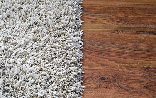 Two part split image of white shaggy carpet and wooden floor