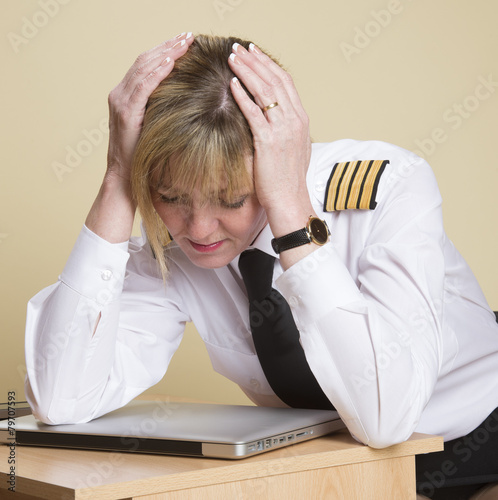 Tired female airline pilot wearing insignia of a captain photo