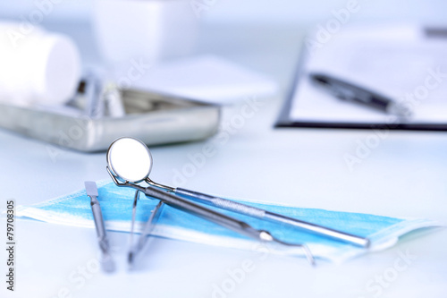 Dentist tools with medical mask on table close up