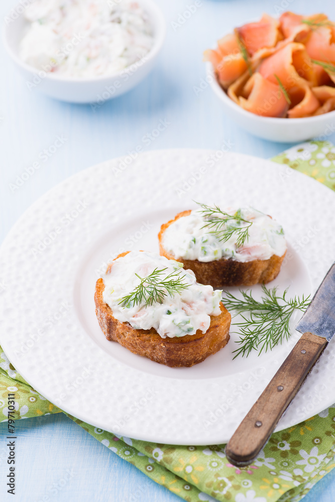 Canapes with soft cheese spread on white plate