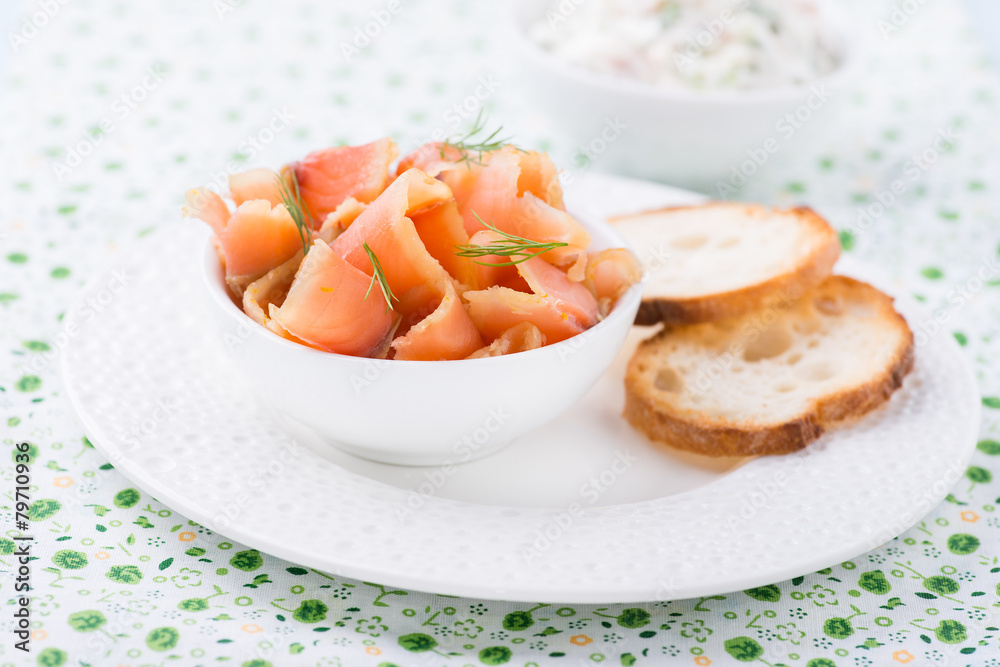 Smoked wild salmon and baguette on white plate Smoked wild salmon and baguette on white plate