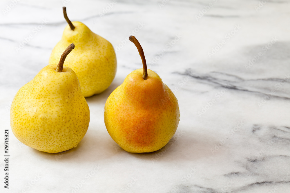 Yellow pears on white marble kitchen counter Yellow pears on white marble kitchen counter
