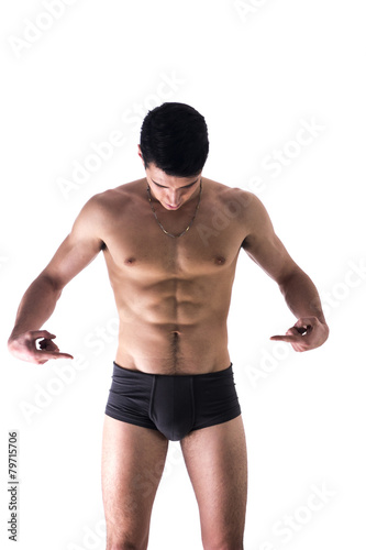 Young man in underwear pointing fingers at empty blank space for