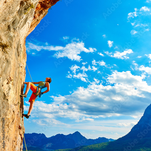Canvas-taulu Rock climber climbing up a cliff