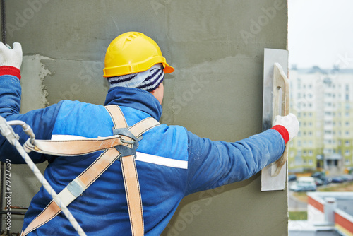 Photos worker at plastering facade work