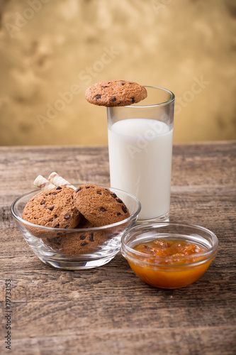 glass of milk and cookie on wooden background