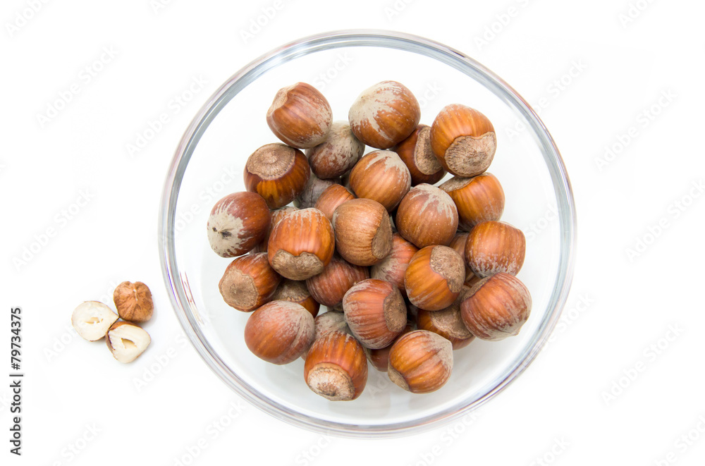 Obraz premium Hazelnuts on bowl on white background viewed from above