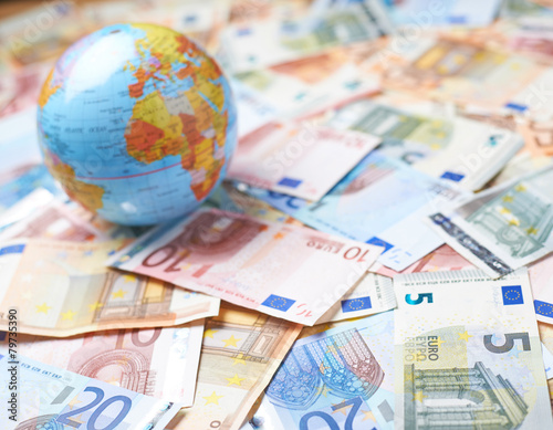 Earth globe over the pile of money