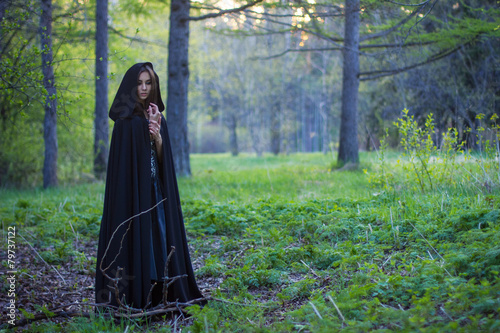 Photography the girl with the black cloak in the forest