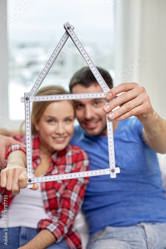 close up of couple with house shape ruler