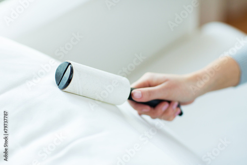 close up of woman hand with sticky roller cleaning