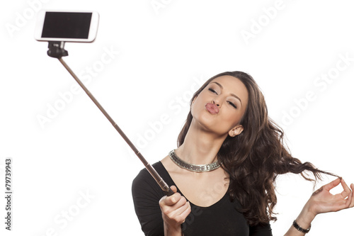 pretty brunette making selfie with a stick