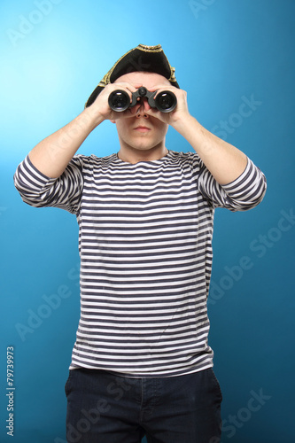  young man in striped clothing looking through binoculars