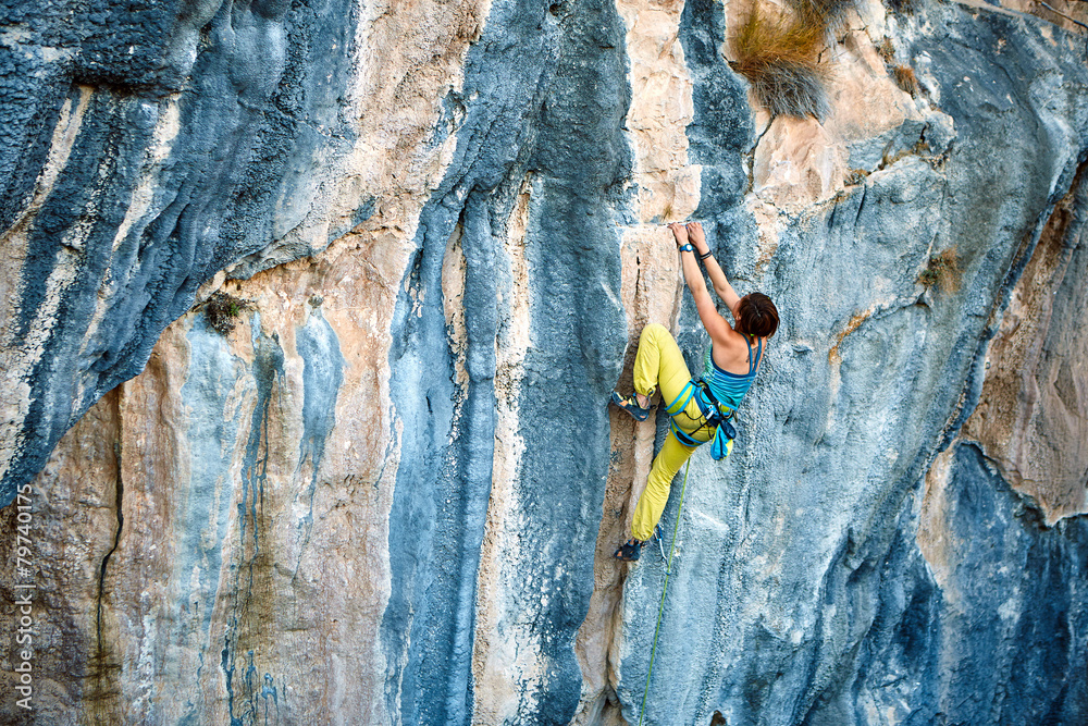 Rock climber climbing up a cliff Rock climber climbing up a cliff