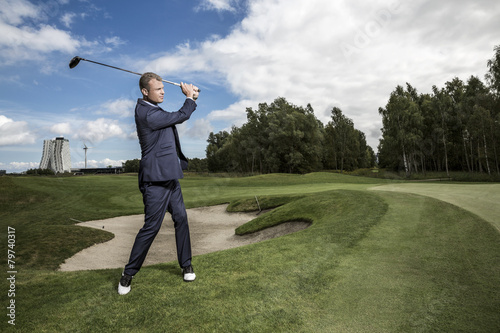 Businessman playing golf outdoors
