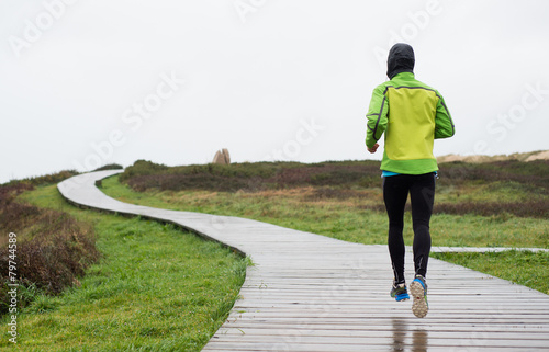 Runner man running in a rainy day