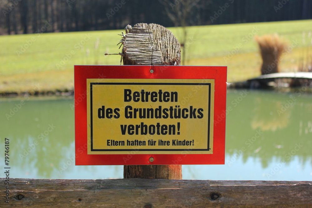 Schild "Betreten des Grundstücks verboten" vor einem Teich Stock Photo