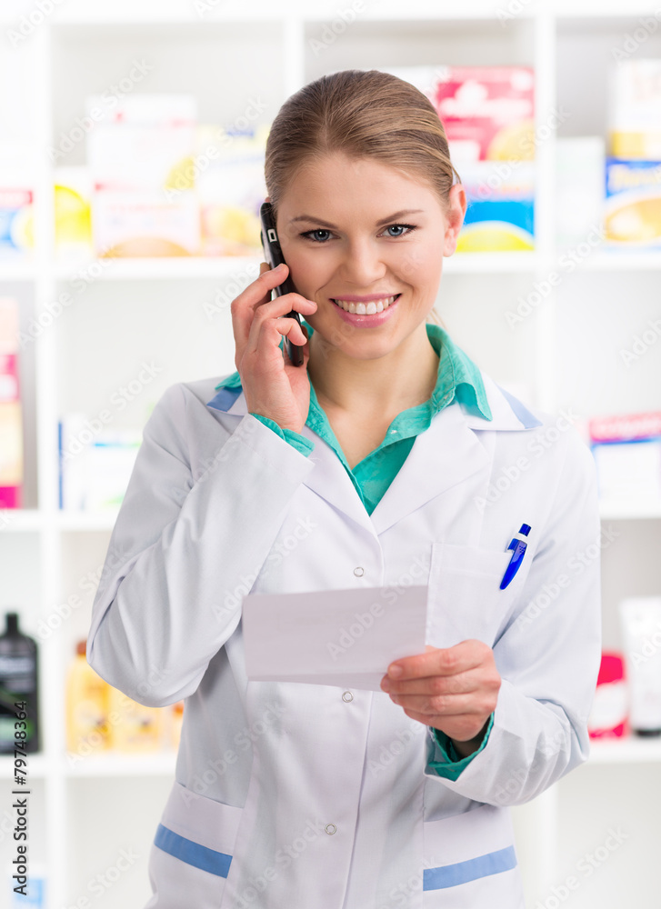 Portrait of attractive woman chemist in uniform talking on phone