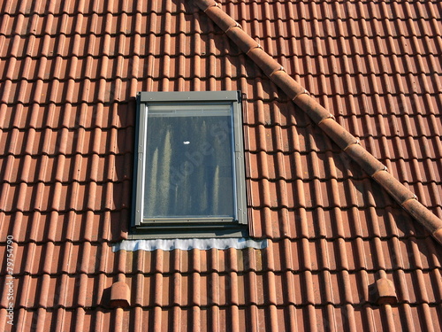 Modernes Dachfenster in einem Walmdach mit rotbraunen Dachziegeln im Sonnenschein im Stadtteil Schildesche in Bielefeld im Teutoburger Wald in Ostwestfalen-Lippe photo