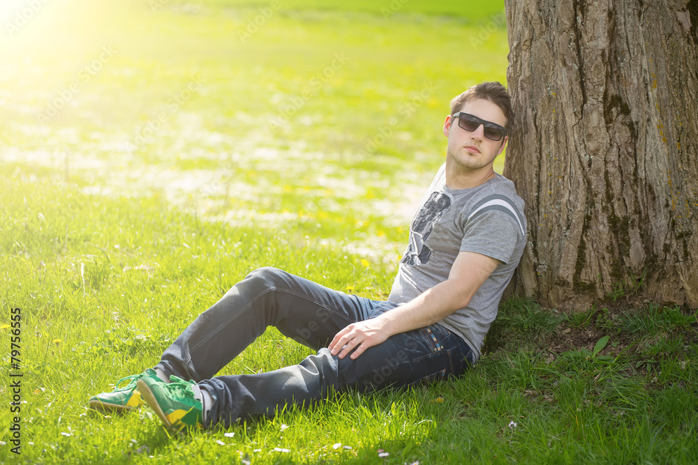 Intimate portrait of man with sunglasses outside in a park. Intimate portrait of man with sunglasses outside in a park.