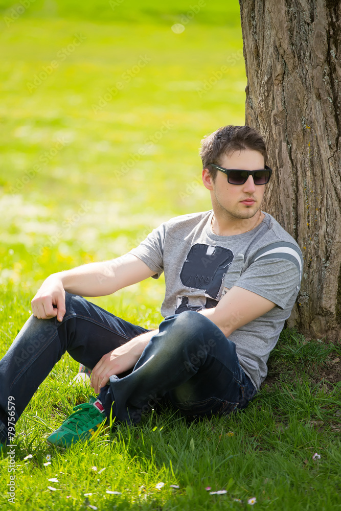Intimate portrait of man with sunglasses outside in a park. Intimate portrait of man with sunglasses outside in a park.