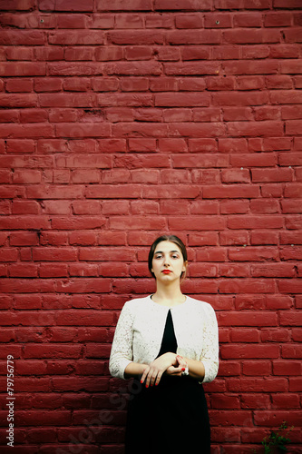Melancholic woman in classic dress near old brick wall outdoor s