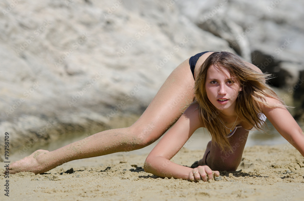 Fitness model with bikini on the sand doing interesting poses Fitness model with bikini on the sand doing interesting poses