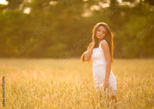 beautiful woman posing in yellow wheat field