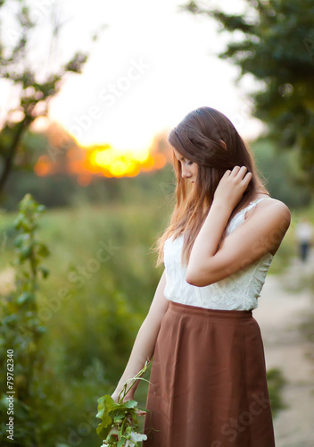young beautiful girl with long hair in the field with flowers