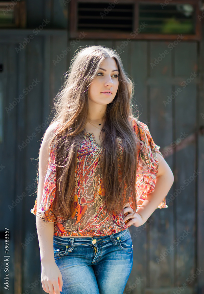 Sexy gorgeous young woman with long hair near old wall