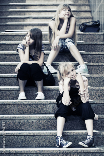 Group of happy teen girls sitting on the steps
