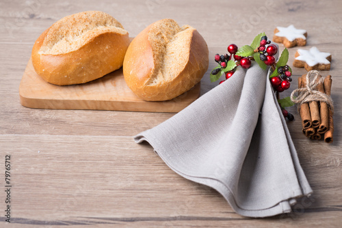 Bread rolls, linen napkin and Christmas decorations photo