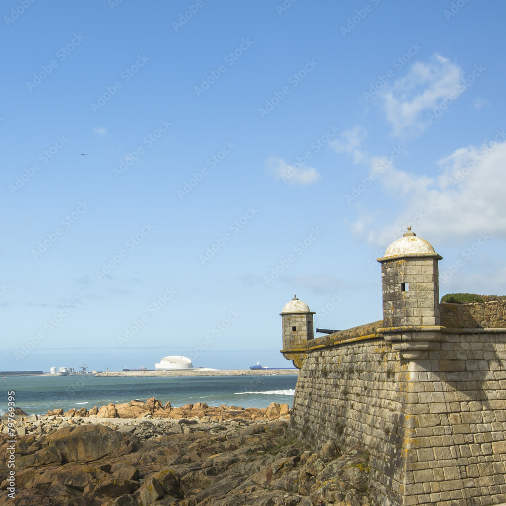 Castle of the Cheese and surf at rocky Atlantic ocean coast.