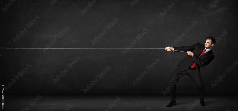 Obraz premium Businessman pulling rope on grey background