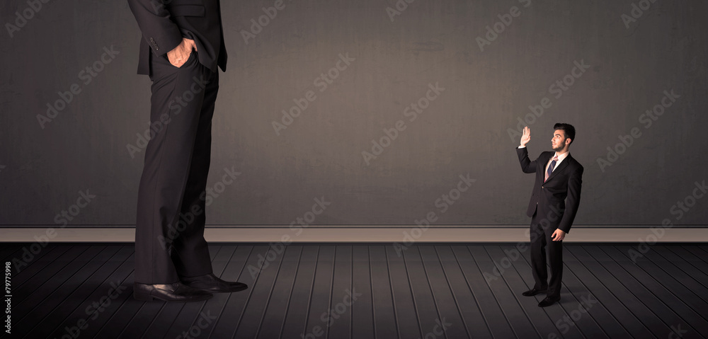 Obraz premium Little bussinesman in front of a giant boss legs concept