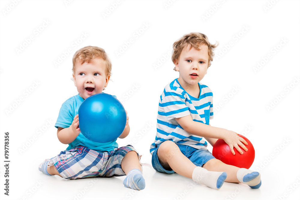 Cute siblings playing with balls isolated on white Cute siblings playing with balls isolated on white