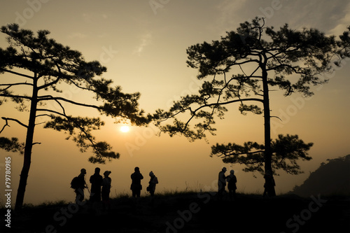 silhouette people on mountain at sunrise